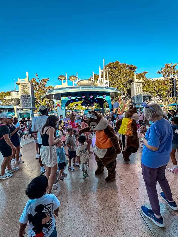 Characters Chip and Dale dancing among children and families during a fun Tomorrowland dance party at Disneyland California.