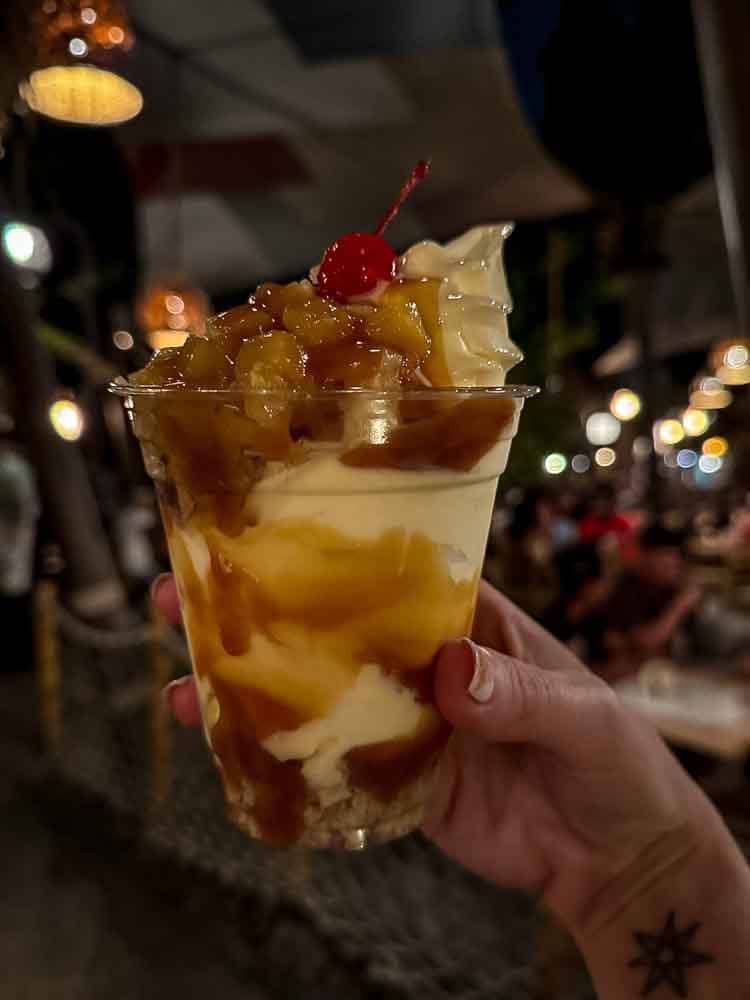 A pineapple Dole Whip Celebration Sundae with caramel, cake, and cherry on top at Disneyland California — a sweet stop on our 3-Day Disneyland California Itinerary.