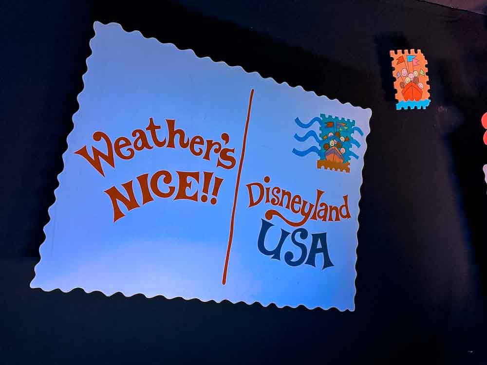 Retro Disneyland USA postcard sign inside It’s a Small World, spotted during our 3-Day Disneyland California Itinerary.