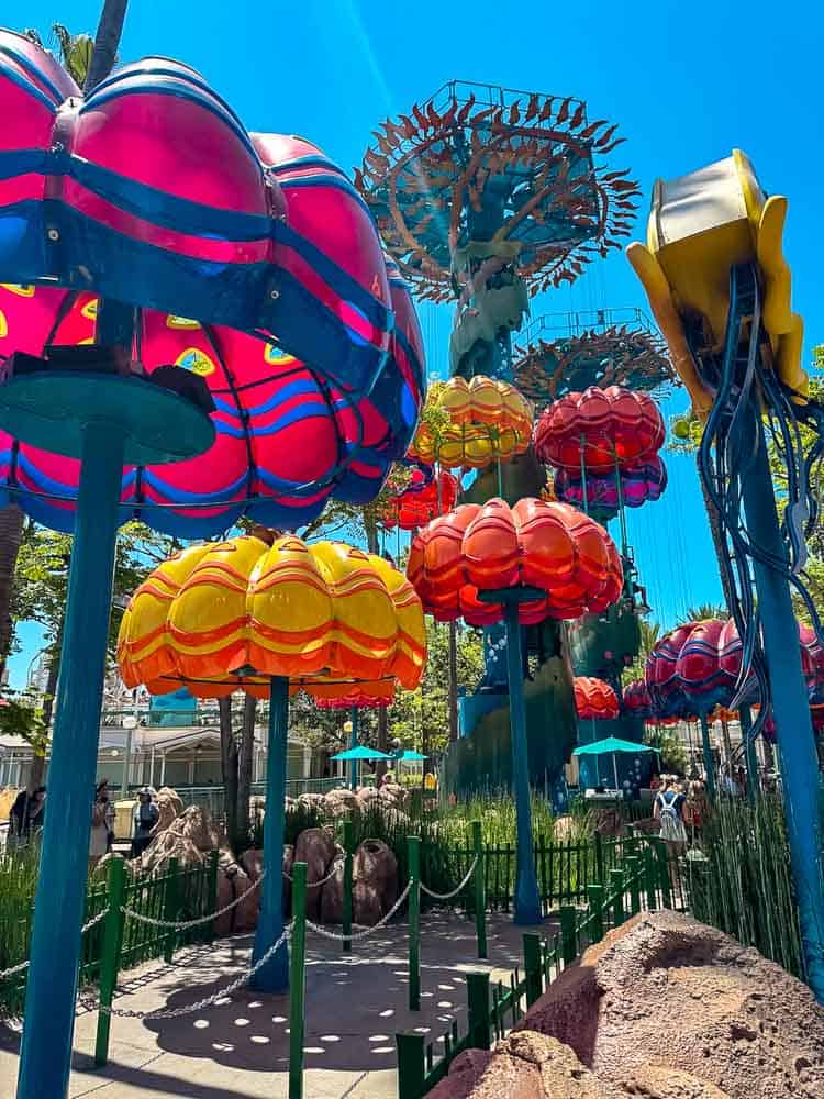 Colourful balloon-like gondolas of the Emotional Whirlwind ride at Pixar Pier spinning against a bright California sky.