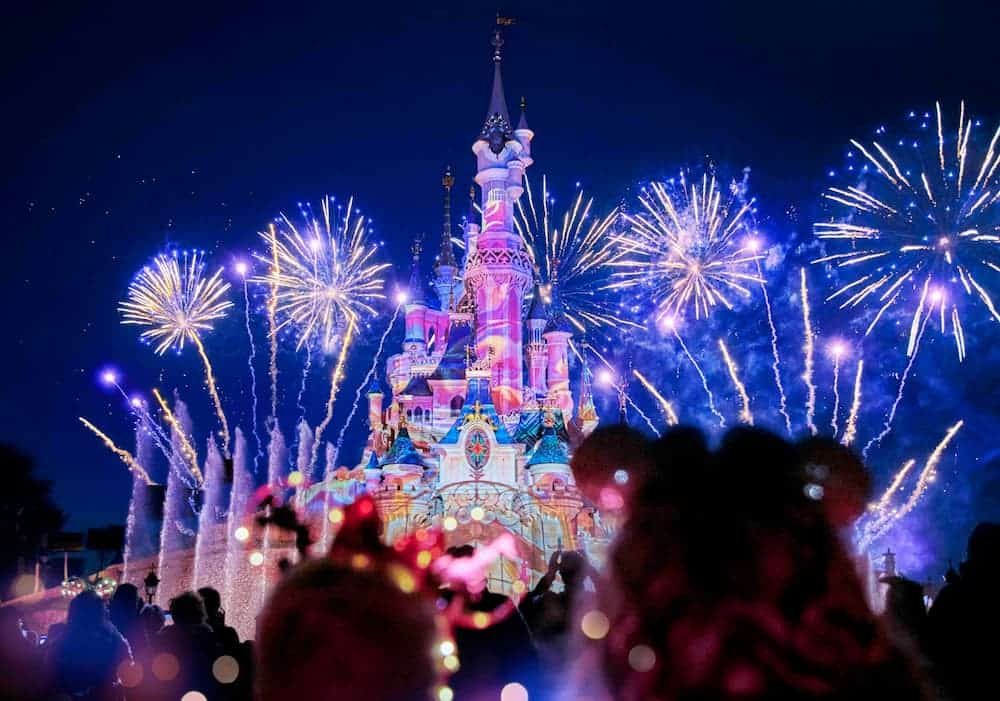 Fireworks above Sleeping Beauty Castle during Disneyland Paris Christmas 2025, with projections and festive colours.
