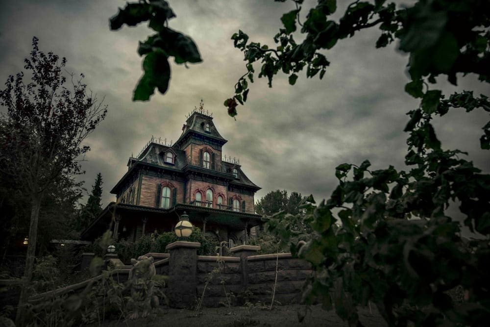 The eerie Phantom Manor mansion with dark skies and autumn trees during Halloween at Disneyland Paris 2025.