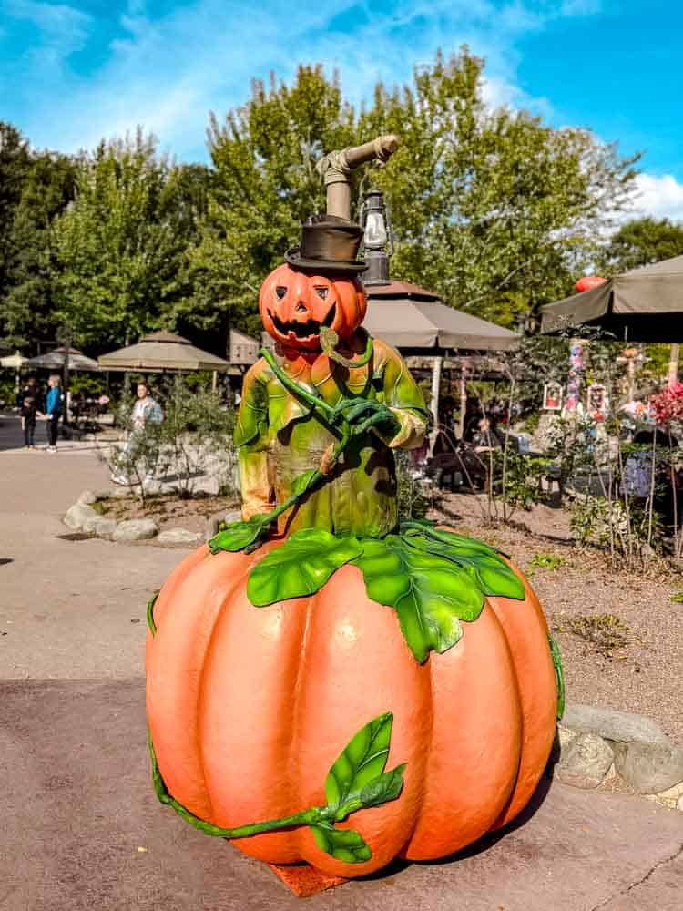 Frontierland pumpkin man statue with jack-o-lantern head and lantern at Disneyland Paris Halloween 2025 decorations