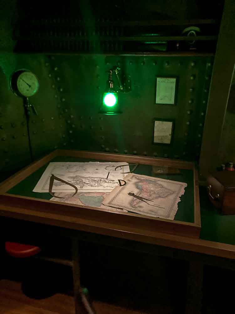 Captain’s desk with antique maps and instruments inside the Nautilus walkthrough at Disneyland Paris – ideal indoor spot on a rainy day.