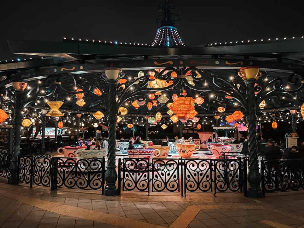 Mad Hatter’s Tea Cups ride at Disneyland Paris in March, lit up at night with colourful lanterns and spinning teacups