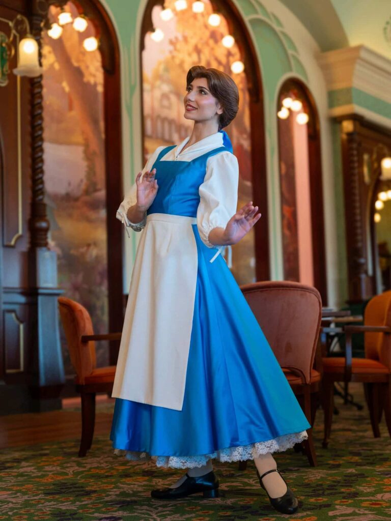 Belle wearing her blue village dress and apron from Beauty and the Beast, similar to the costume seen at Regal View in Disneyland Paris