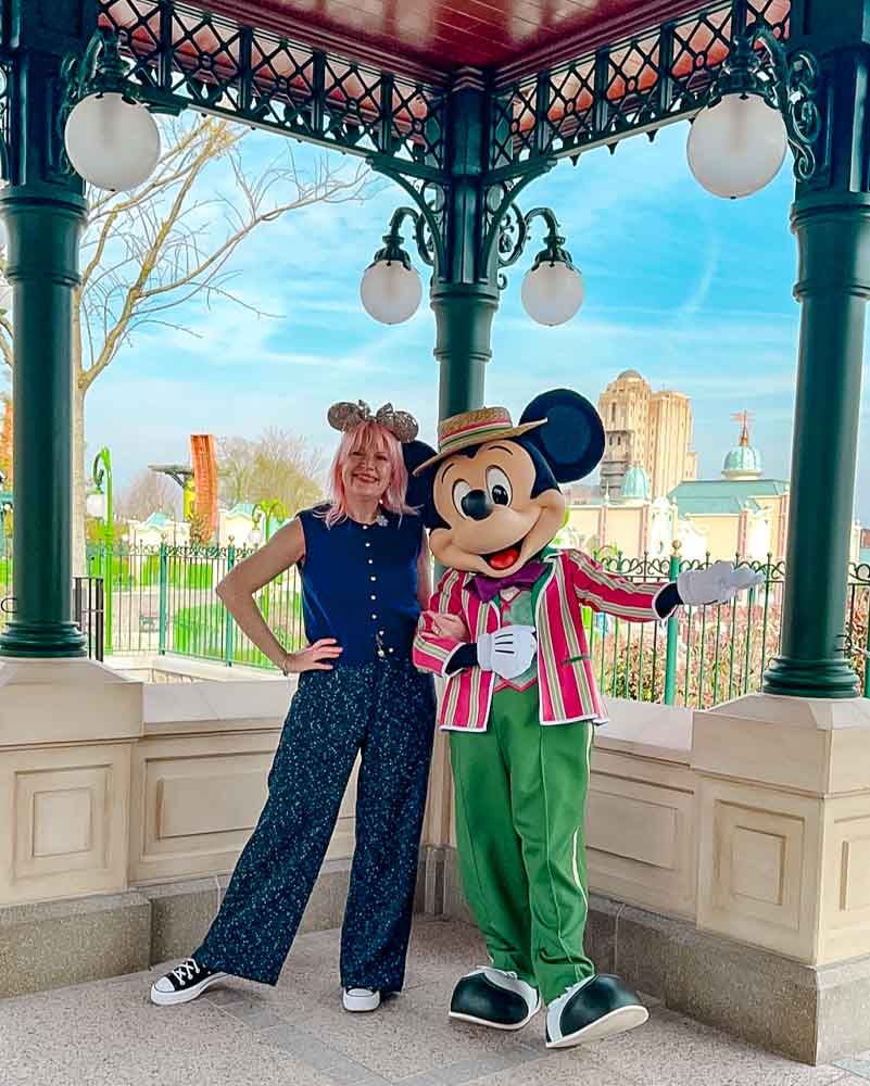 Guest meeting Mickey Mouse in Victorian suit with red stripes at Adventure Way in Disney Adventure World Disneyland Paris