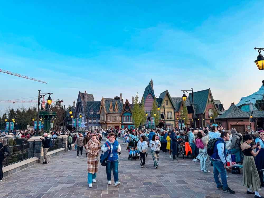 Crowds walking through World of Frozen at Disney Adventure World showing popularity and if it is worth visiting Disneyland Paris
