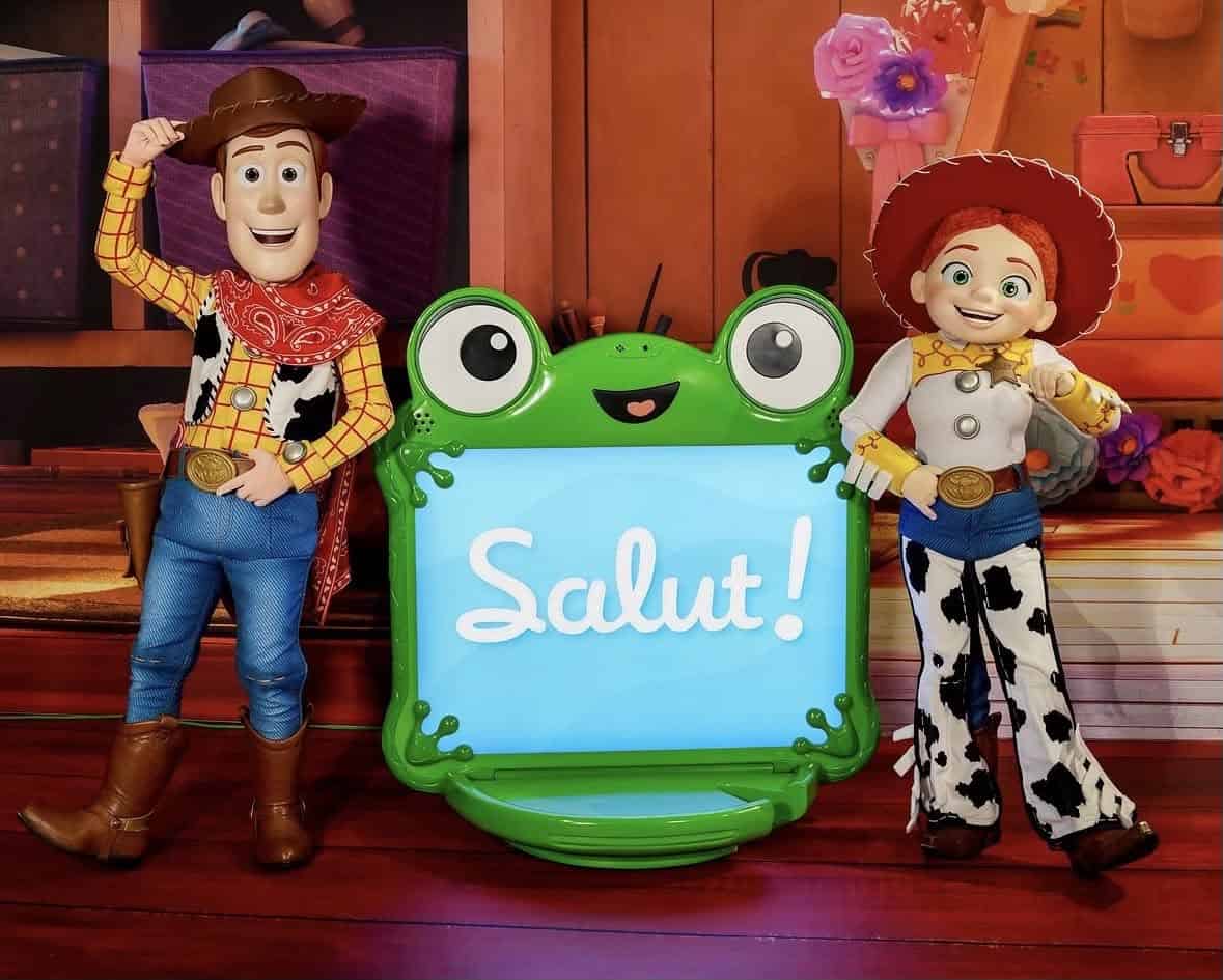 Woody and Jessie meeting guests beside a Toy Story 'Salut!' welcome screen at Disneyland Paris