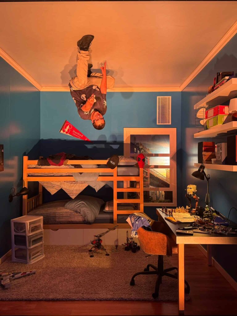 A man pretending to be Spiderman, upside down in the Art of Marvel Hotel Hotel New York Disneyland Paris
