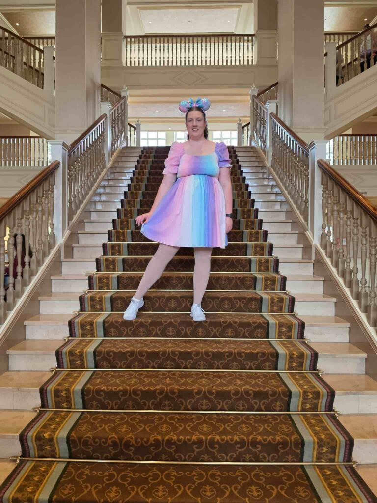 A lady standing on the stairs in the Disneyland Paris Hotel lobby