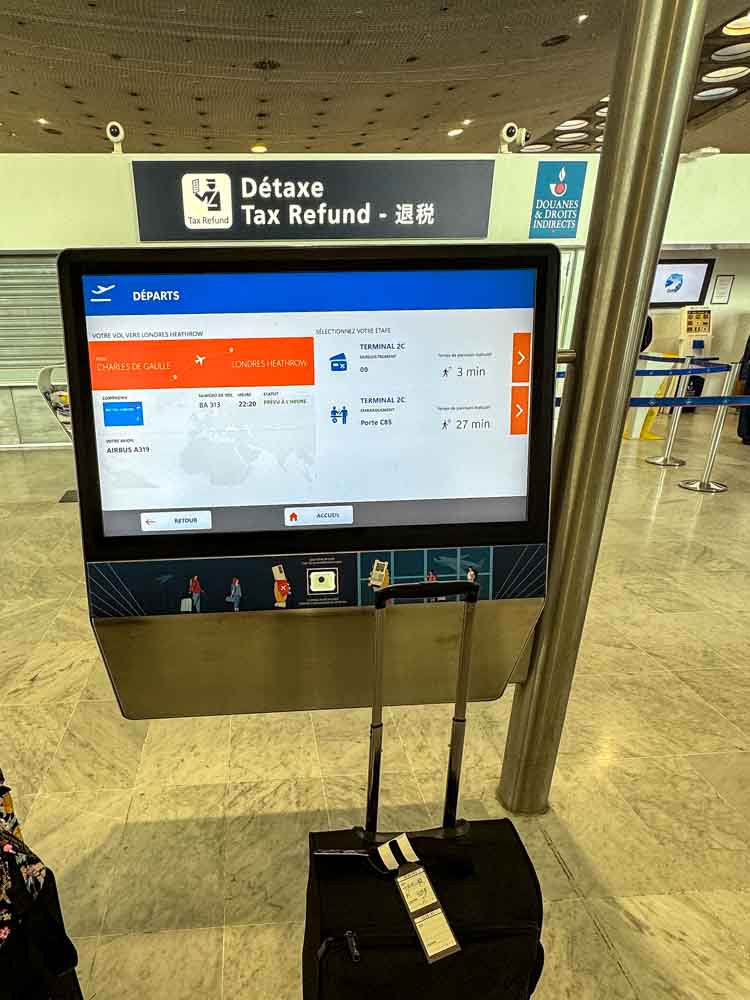 Self-service departure and tax refund screen at Charles de Gaulle Airport, showing terminal and gate walking times