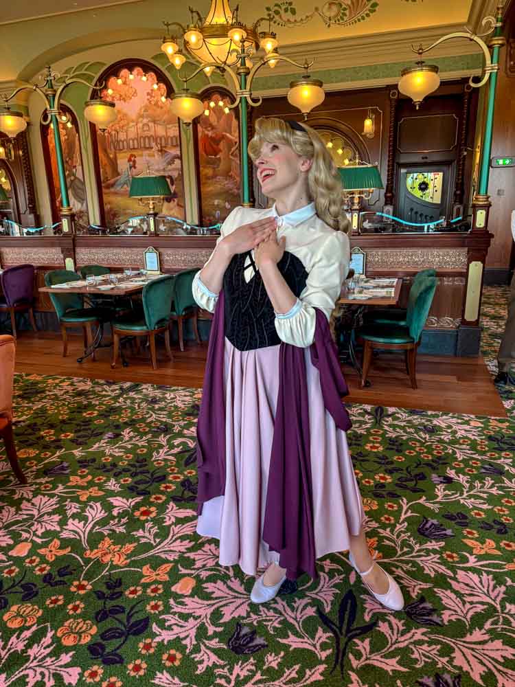 Briar Rose poses for guests in her forest dress at Regal View, one of Disneyland Paris best restaurants